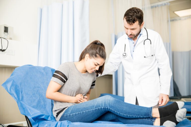 woman with stomach ache visiting doctor